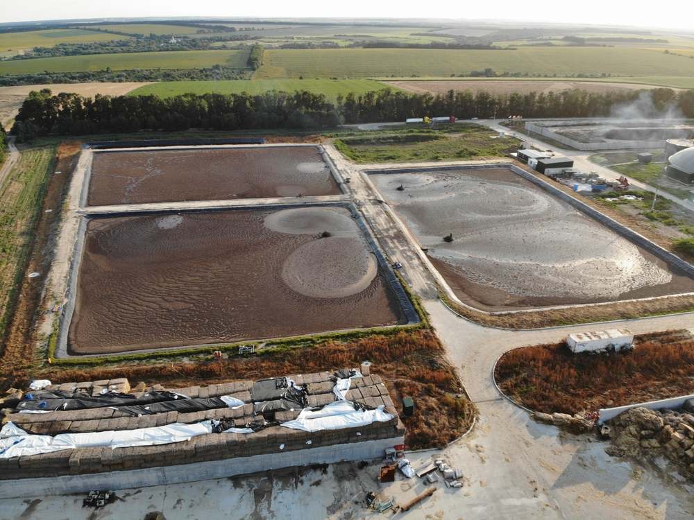 Aerial view of wastewater lagoons lying still under flat grey light